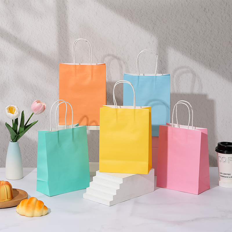 Bonbonfarbene Einkaufstaschen aus Kraftpapier mit gedrehten Papiergriffen