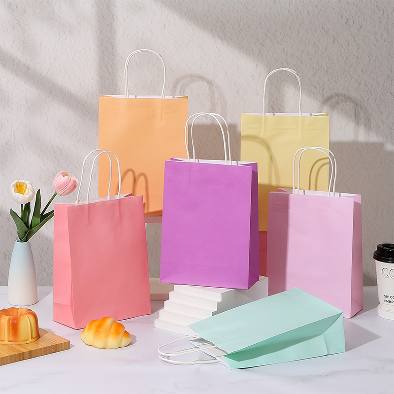 Bonbonfarbene Einkaufstaschen aus Kraftpapier mit gedrehten Papiergriffen