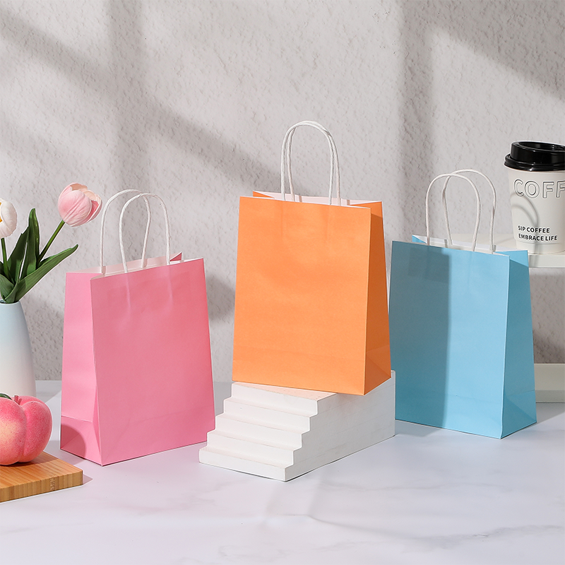 Bonbonfarbene Einkaufstaschen aus Kraftpapier mit gedrehten Papiergriffen