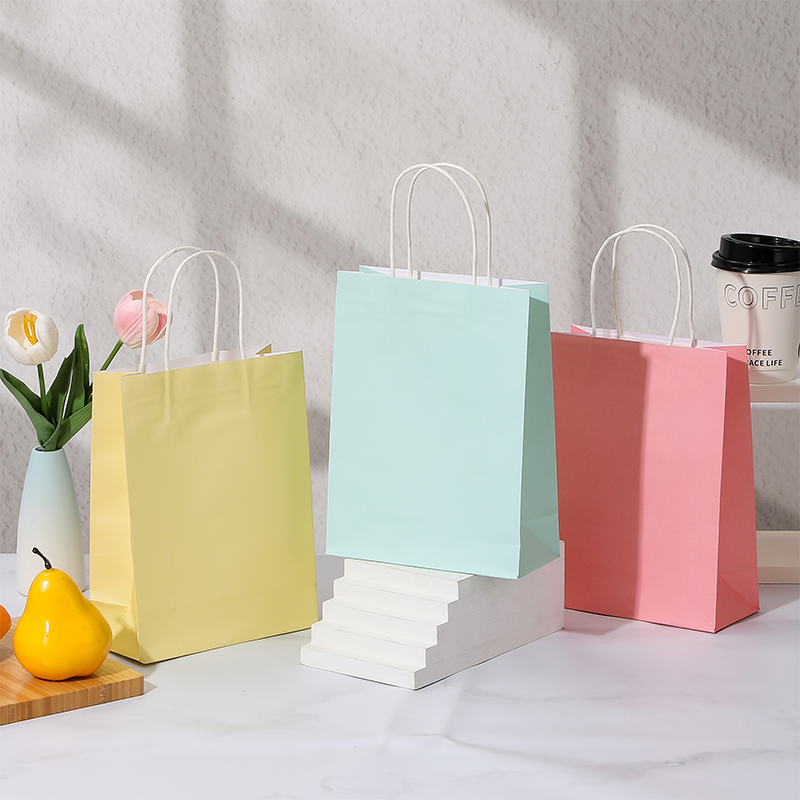 Bonbonfarbene Einkaufstaschen aus Kraftpapier mit gedrehten Papiergriffen