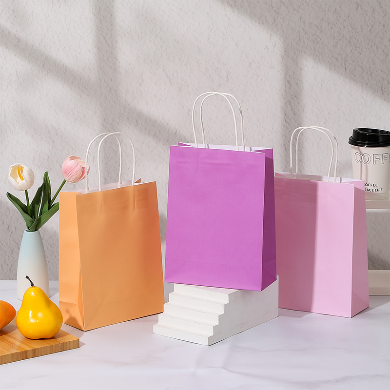 Bonbonfarbene Einkaufstaschen aus Kraftpapier mit gedrehten Papiergriffen