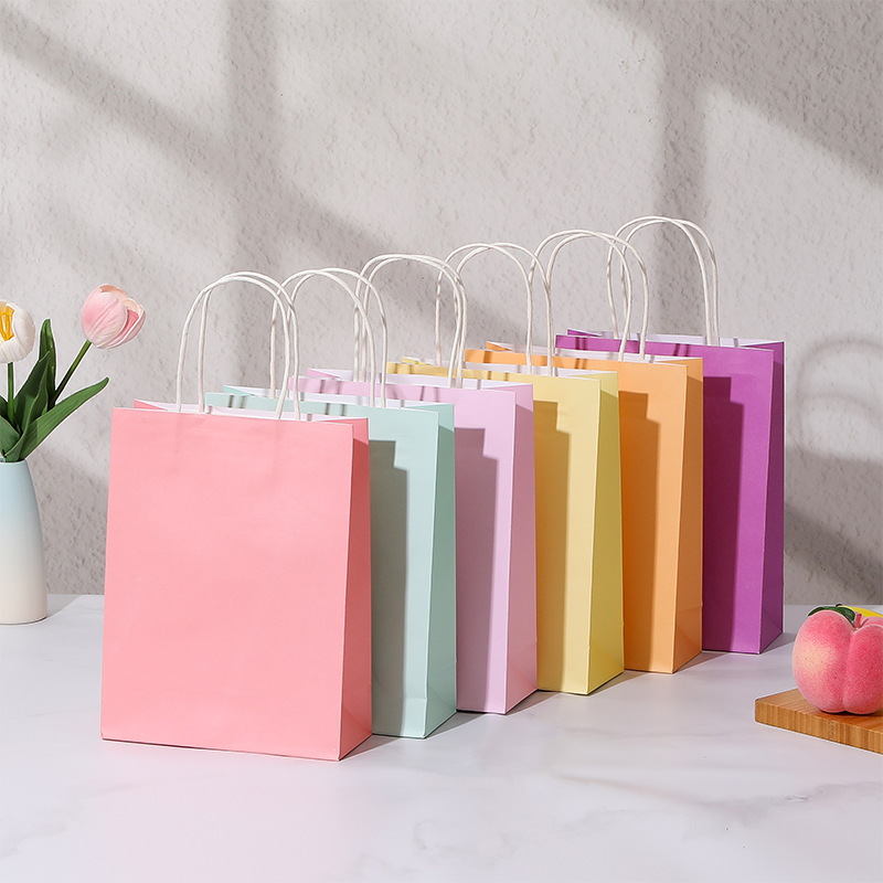 Bonbonfarbene Einkaufstaschen aus Kraftpapier mit gedrehten Papiergriffen