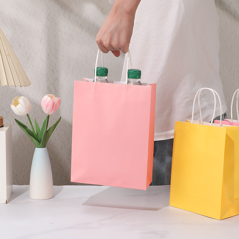 Bonbonfarbene Einkaufstaschen aus Kraftpapier mit gedrehten Papiergriffen